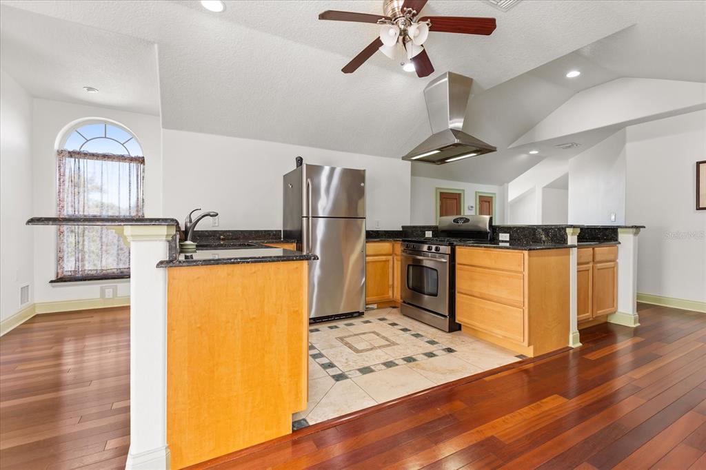 1501 Lake Markham Road Sanford, FL 32771 - Photo 85 of 93 a kitchen with stainless steel appliances granite countertop a refrigerator a stove and a sink with wooden floor