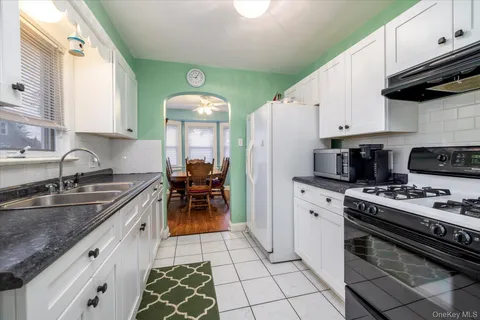 a kitchen with granite countertop a sink stove and cabinets