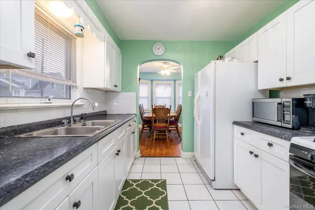 a kitchen with granite countertop a sink cabinets and stainless steel appliances