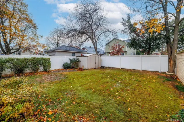 a view of a house with a large tree and a yard