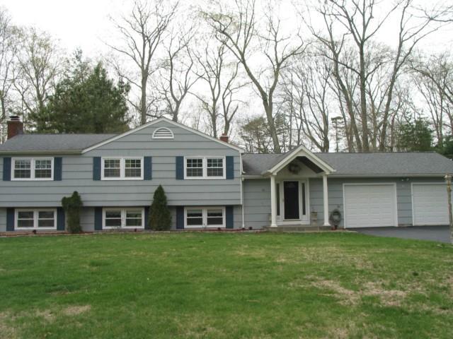 a front view of a house with a garden and trees