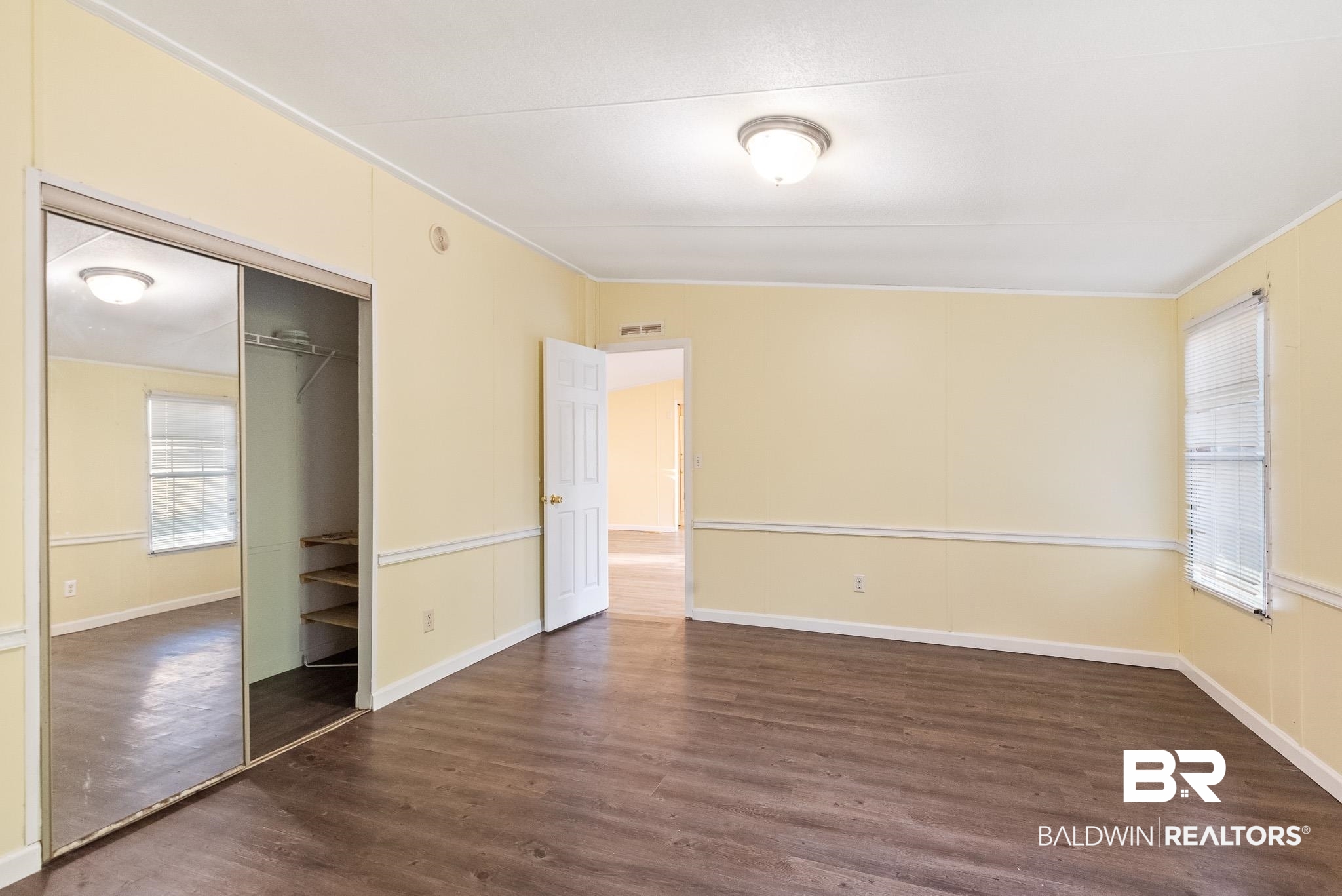 7695 Bermuda Drive Semmes, AL 36575 - Photo 16 of 27 Unfurnished bedroom featuring a closet, baseboards, visible vents, and wood finished floors