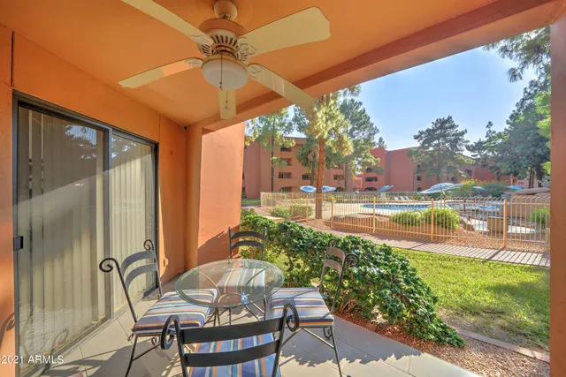 a patio with yard glass top table and chairs