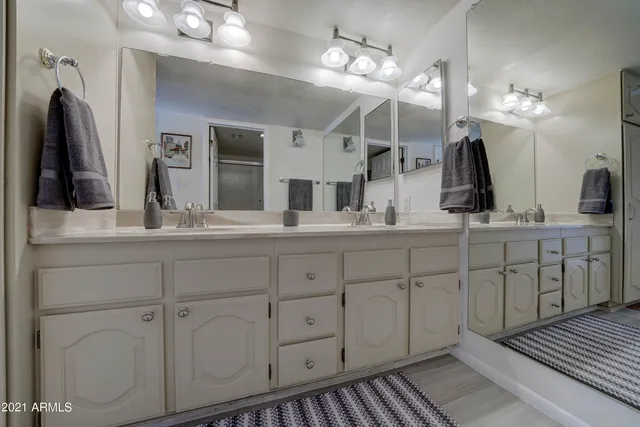 a bathroom with a double vanity sink and a mirror
