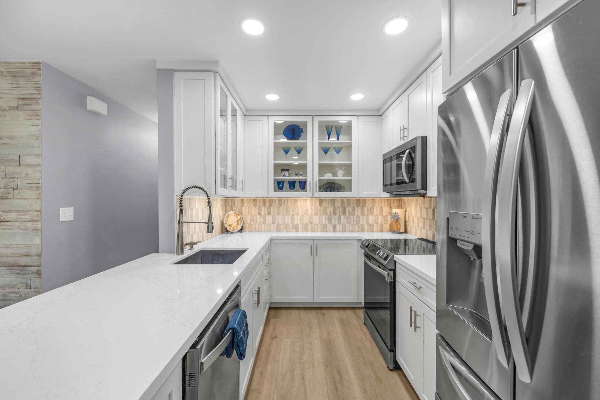 140 Uwapo Road, Unit 36104 Kihei, HI 96753 - Photo 12 of 33 a kitchen with kitchen island a sink appliances and cabinets