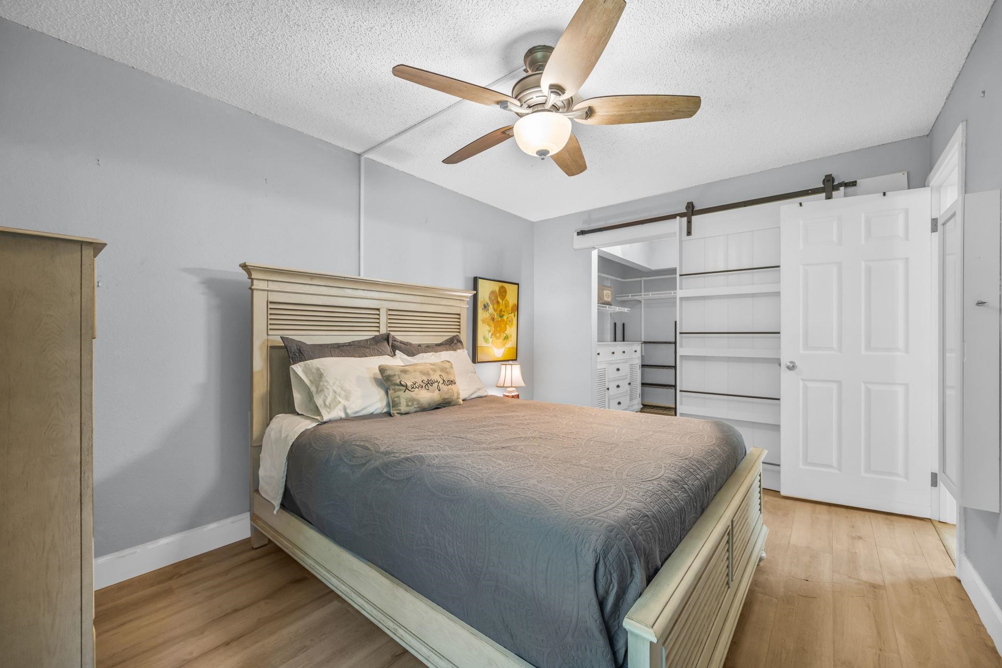 140 Uwapo Road, Unit 36104 Kihei, HI 96753 - Photo 14 of 33 a bedroom with a large bed and a ceiling fan