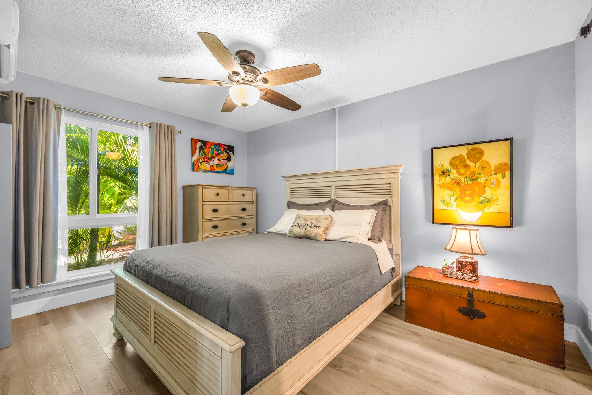 140 Uwapo Road, Unit 36104 Kihei, HI 96753 - Photo 4 of 33 a bedroom with a bed and a chandelier