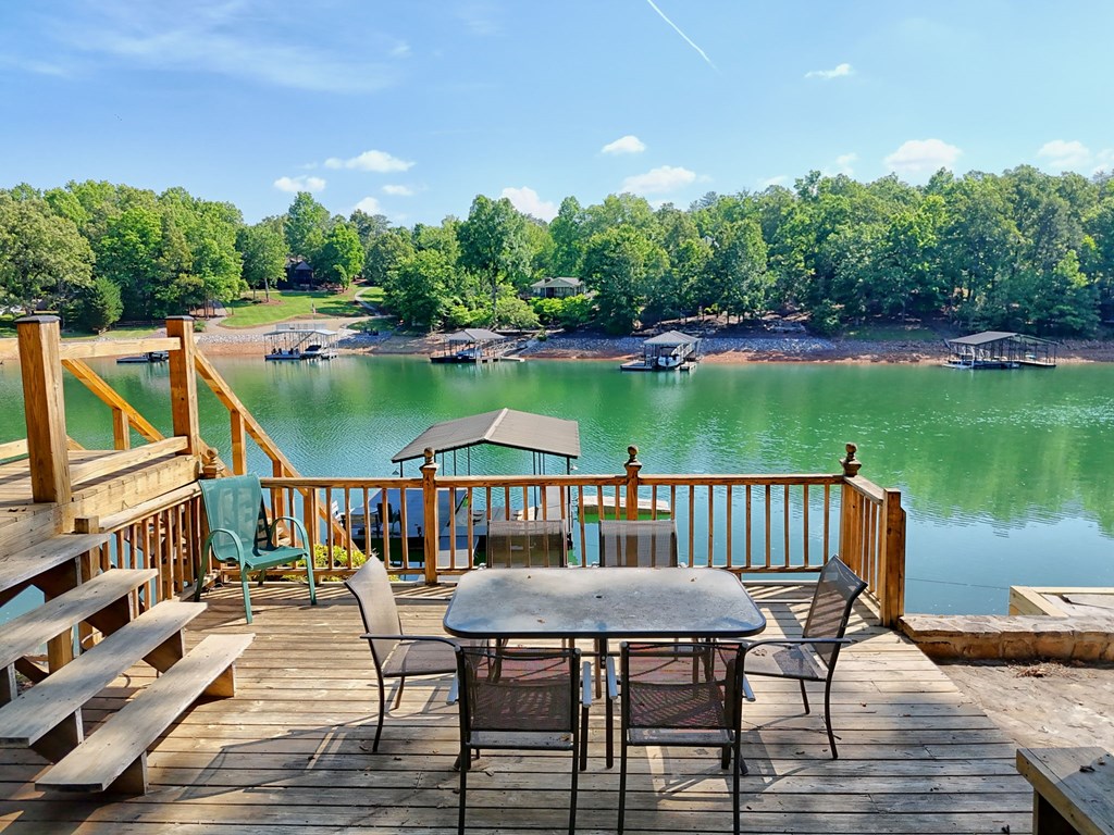 456 Deaver Cove Road Blairsville, GA 30512 - Photo 75 of 83 a view of a roof deck with table and chairs a barbeque with wooden floor and fence