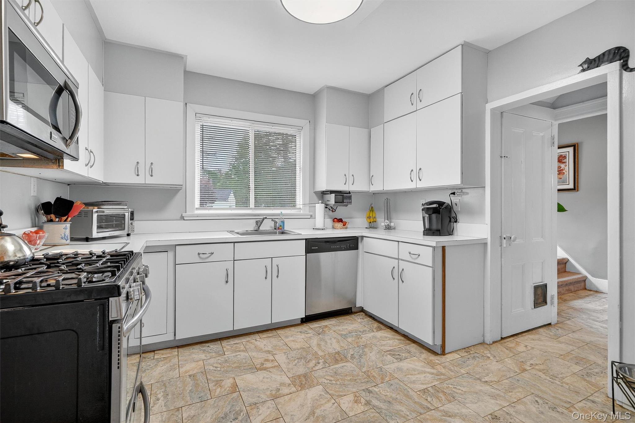 134 Dalmeny Road Briarcliff Manor, NY 10510 - Photo 13 of 44 a kitchen with cabinets appliances and a window
