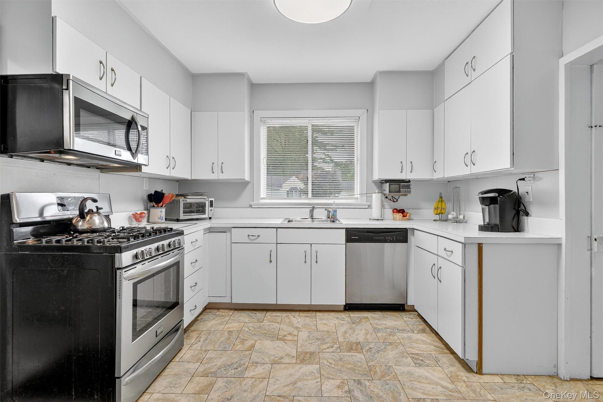 134 Dalmeny Road Briarcliff Manor, NY 10510 - Photo 14 of 44 a kitchen with granite countertop white cabinets a sink a window and stainless steel appliances