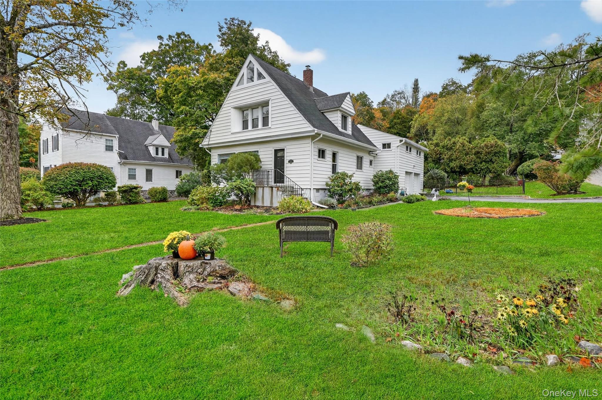 134 Dalmeny Road Briarcliff Manor, NY 10510 - Photo 5 of 44 a front view of a house with a yard table and chairs