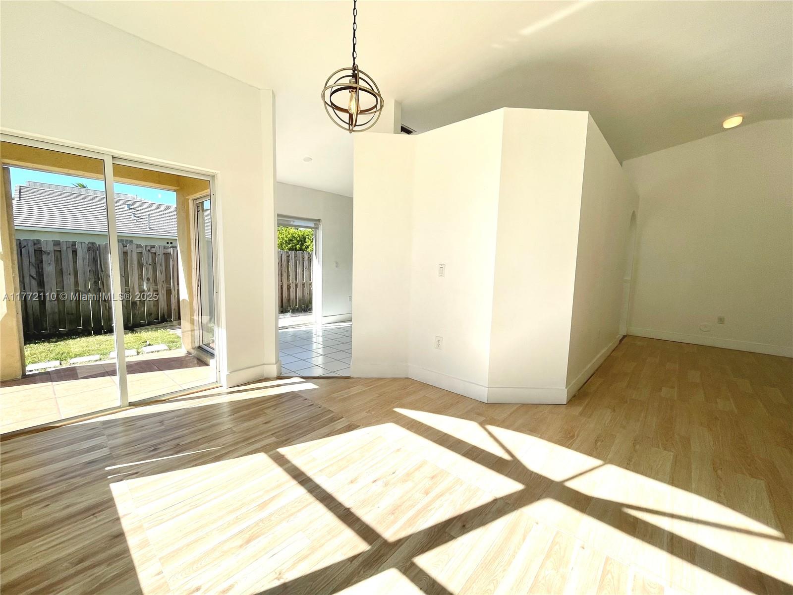 a view of a room with wooden floor and windows