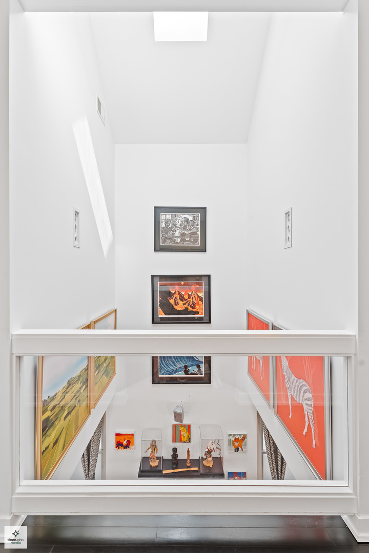 3036 North Gresham Avenue Chicago, IL 60618 - Photo 20 of 31 a view of a hallway with a lots of frames on the wall