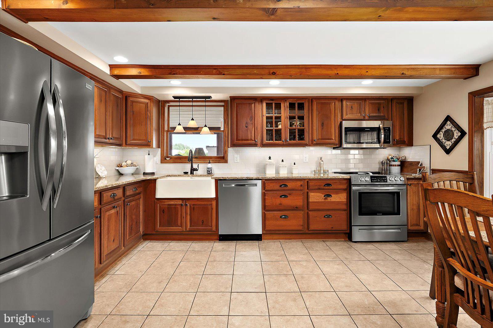 8807 Woodland Ferry Road Laurel, DE 19956 - Photo 25 of 90 a kitchen with stainless steel appliances granite countertop a stove top oven a sink and a refrigerator