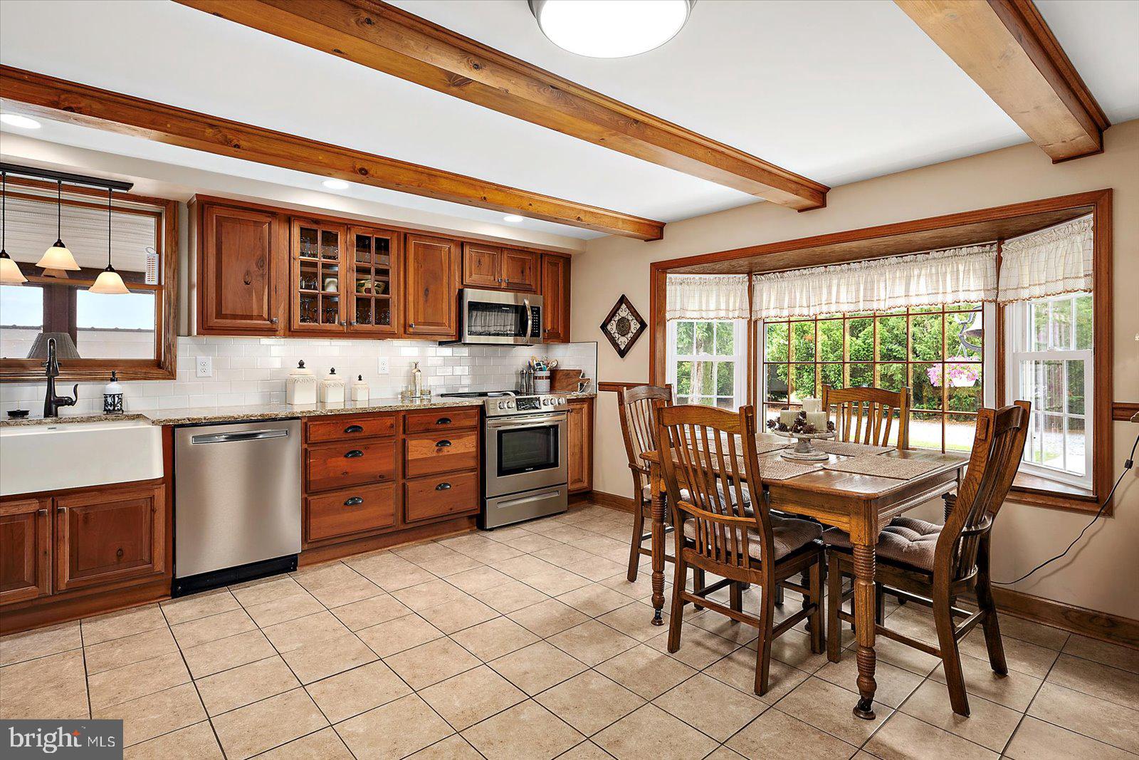 8807 Woodland Ferry Road Laurel, DE 19956 - Photo 26 of 90 a kitchen with a table chairs sink and cabinets