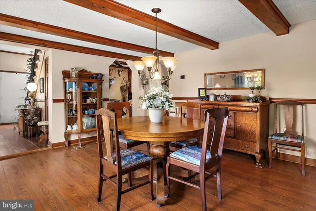a kitchen that has a table chairs and wooden floors