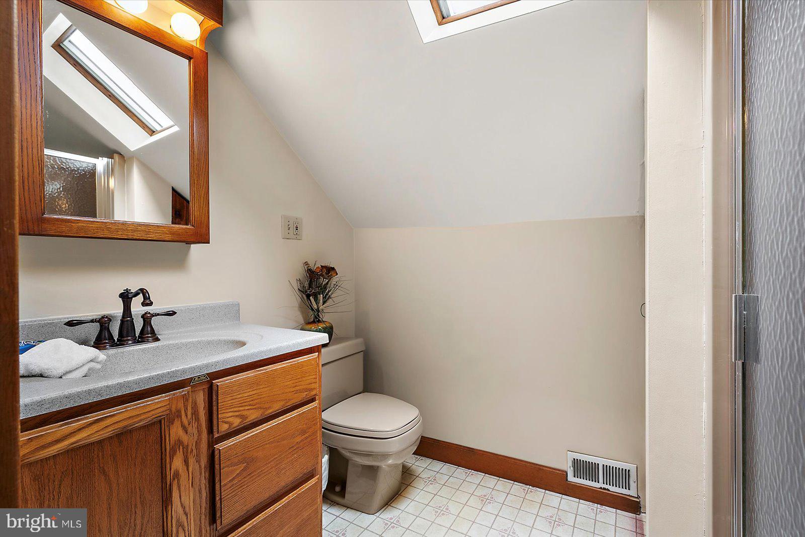 8807 Woodland Ferry Road Laurel, DE 19956 - Photo 51 of 90 a bathroom with a granite countertop toilet a sink and a mirror