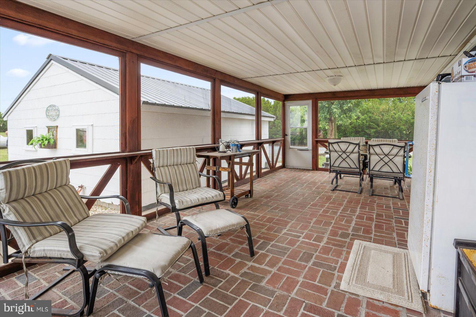 8807 Woodland Ferry Road Laurel, DE 19956 - Photo 60 of 90 a view of a patio with a table chairs and wooden floor