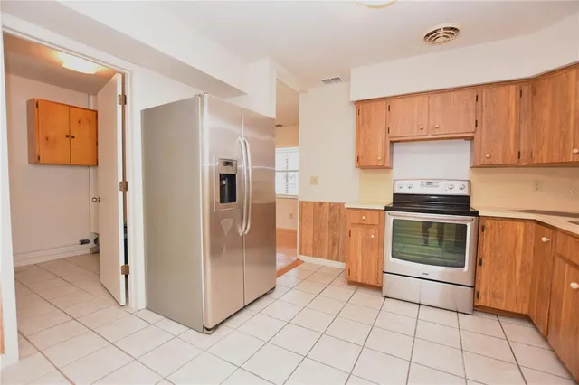 a kitchen with granite countertop a refrigerator and a stove top oven