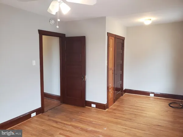 an empty room with wooden floor and closet