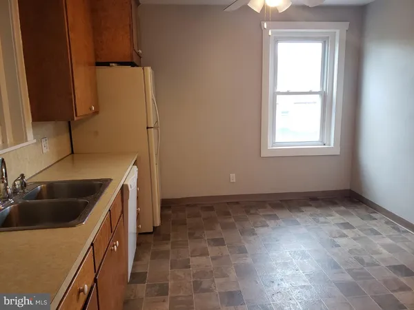 a kitchen with a sink a refrigerator and cabinets