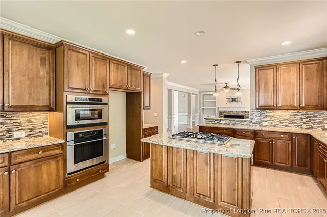 a kitchen with stainless steel appliances granite countertop a stove top oven a sink and a refrigerator