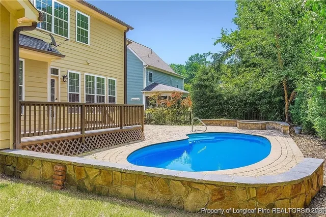 a view of swimming pool with deck and patio