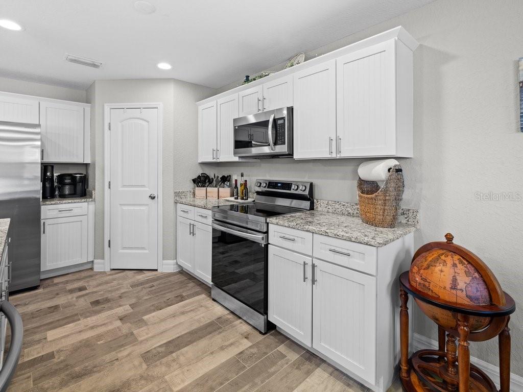 8221 Agate Street Port Charlotte, FL 33981 - Photo 22 of 50 a kitchen with stainless steel appliances granite countertop a stove a sink and a refrigerator