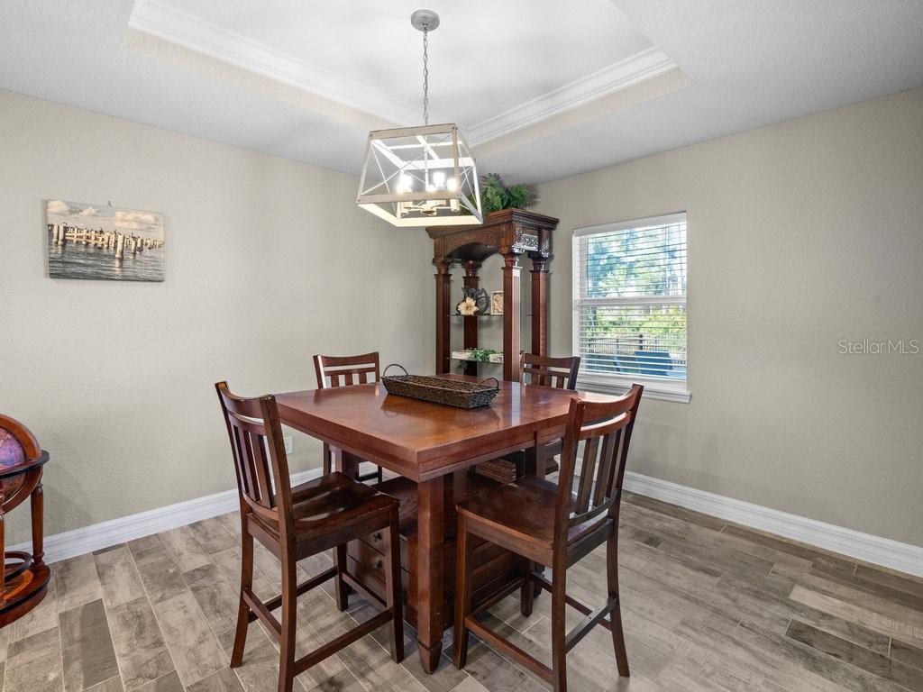 8221 Agate Street Port Charlotte, FL 33981 - Photo 25 of 50 a view of a dining room with furniture a chandelier and wooden floor