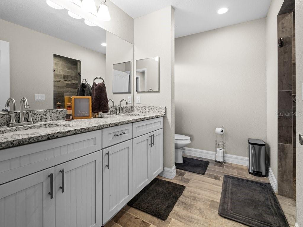 8221 Agate Street Port Charlotte, FL 33981 - Photo 31 of 50 a spacious bathroom with a granite countertop sink and a mirror