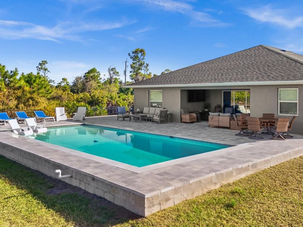 8221 Agate Street Port Charlotte, FL 33981 - Photo 43 of 50 a swimming pool view with a seating space and a garden view
