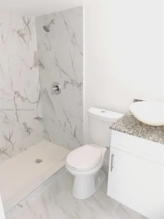 a bathroom with a granite countertop toilet sink and mirror