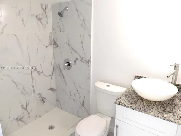 a bathroom with a toilet sink and shower