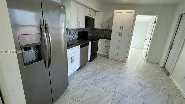 a kitchen with stainless steel appliances granite countertop a refrigerator and a sink