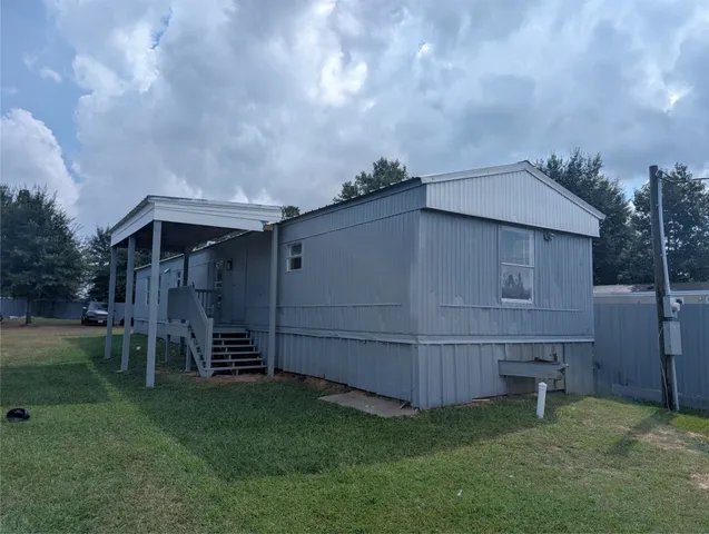 a backyard of a house with lots of green space and wooden fence