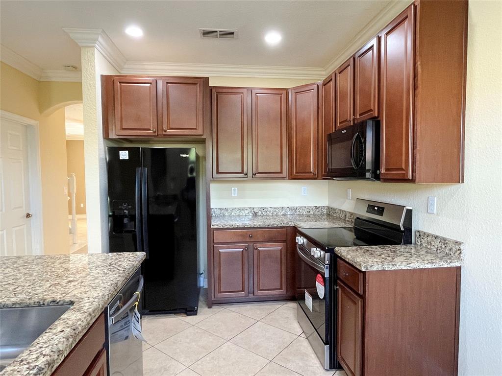 291 Lake Monterey Circle Boynton Beach, FL 33426 - Photo 11 of 47 a kitchen with stainless steel appliances granite countertop a stove and a refrigerator