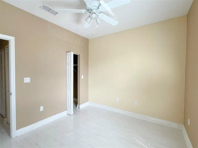 an empty room with closet and a hallway