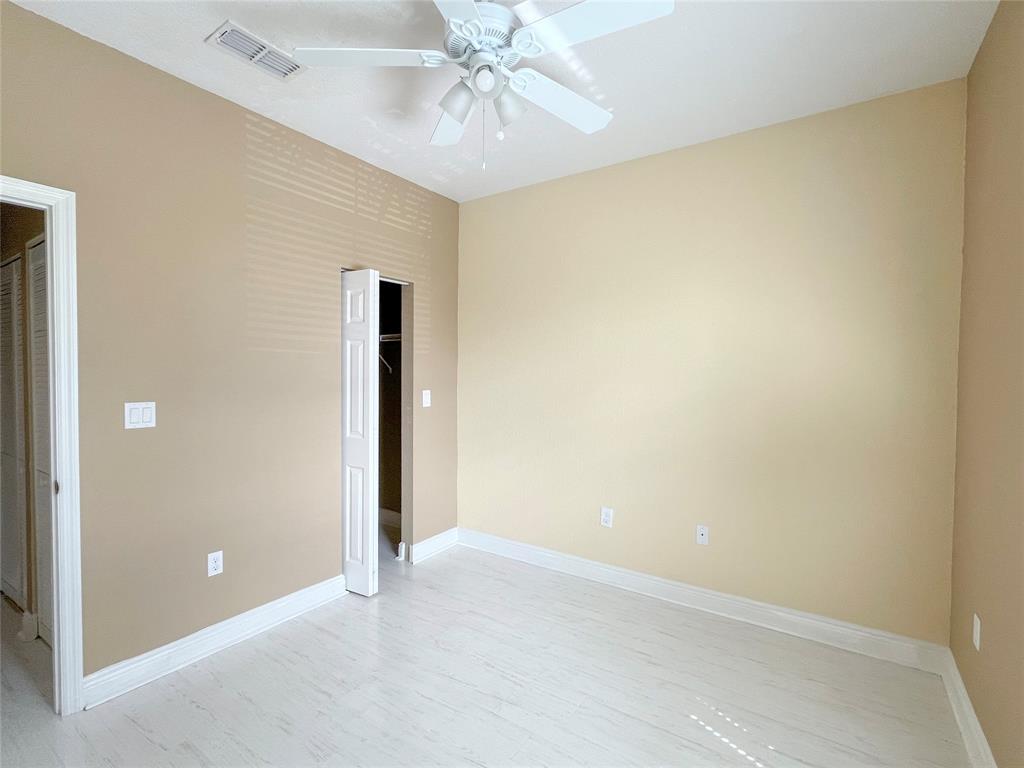 291 Lake Monterey Circle Boynton Beach, FL 33426 - Photo 35 of 47 an empty room with a ceiling fan and carpet