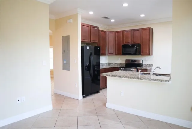 a kitchen with granite countertop a refrigerator and a sink