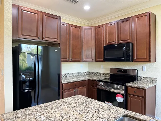 a kitchen with stainless steel appliances granite countertop a stove and a refrigerator