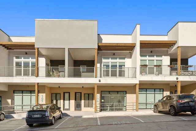 front view of a building that has a couple of cars parked in front of it