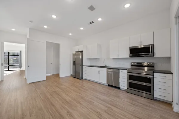 a view of kitchen with stainless steel appliances granite countertop a stove a sink and a refrigerator