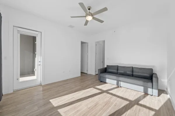 a living room with furniture and a wooden floor