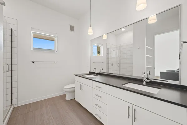 a bathroom with a granite countertop sink a toilet and a mirror