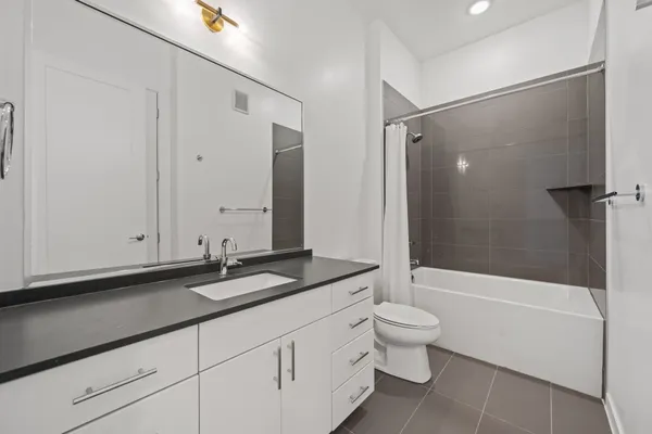 a bathroom with a granite countertop sink a toilet and shower