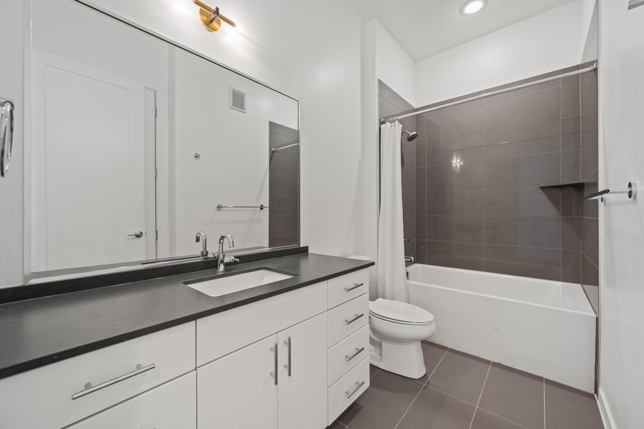 4901 Springdale Road, Unit 106 Austin, TX 78723 - Photo 26 of 40 a bathroom with a granite countertop sink a toilet and shower