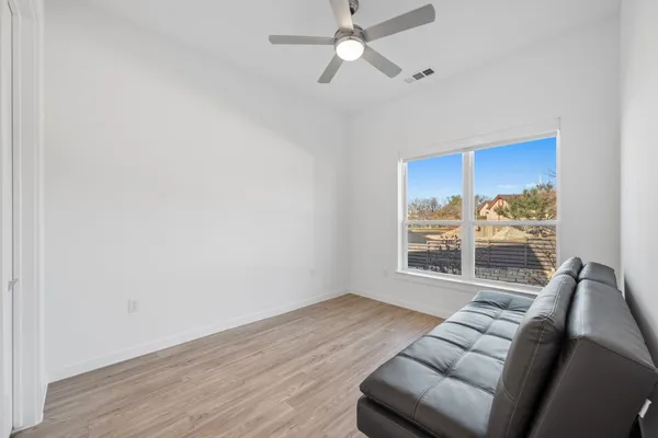 a living room with furniture a ceiling fan and a window