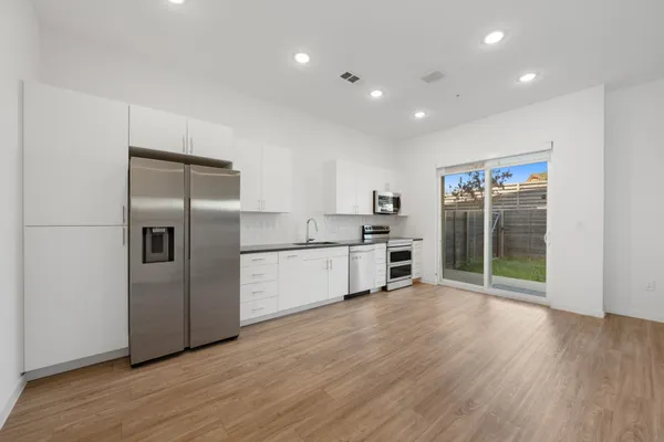 a kitchen with stainless steel appliances granite countertop a refrigerator and a sink