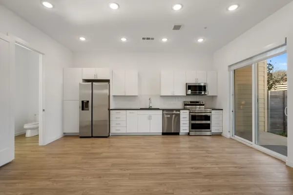 a large kitchen with stainless steel appliances a refrigerator and a stove top oven