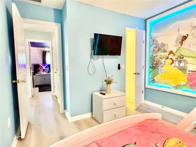 a bedroom with a bed and flat tv screen on dresser